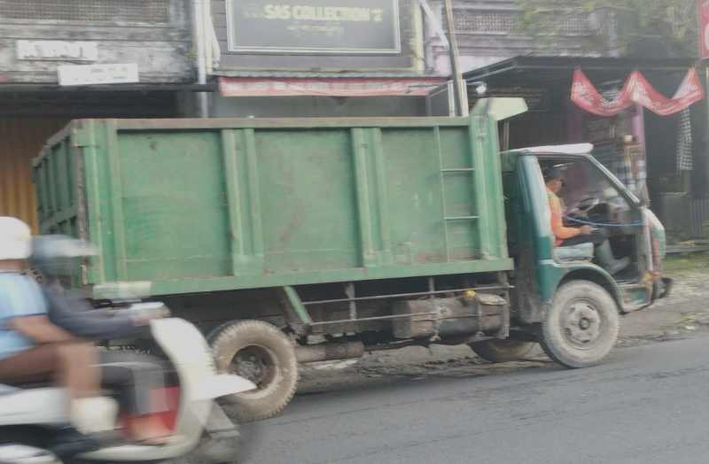 BUKAN SYUTING FILM, INI BENERAN : Beginilah kondisi truk sampah milik Pemkab Tabanan, tanpa pintu dan masih beroperasi untuk mengangkut sampah di Jalan Pahlawan Delod Peken,Tabanan.(juliadi/radarbali)