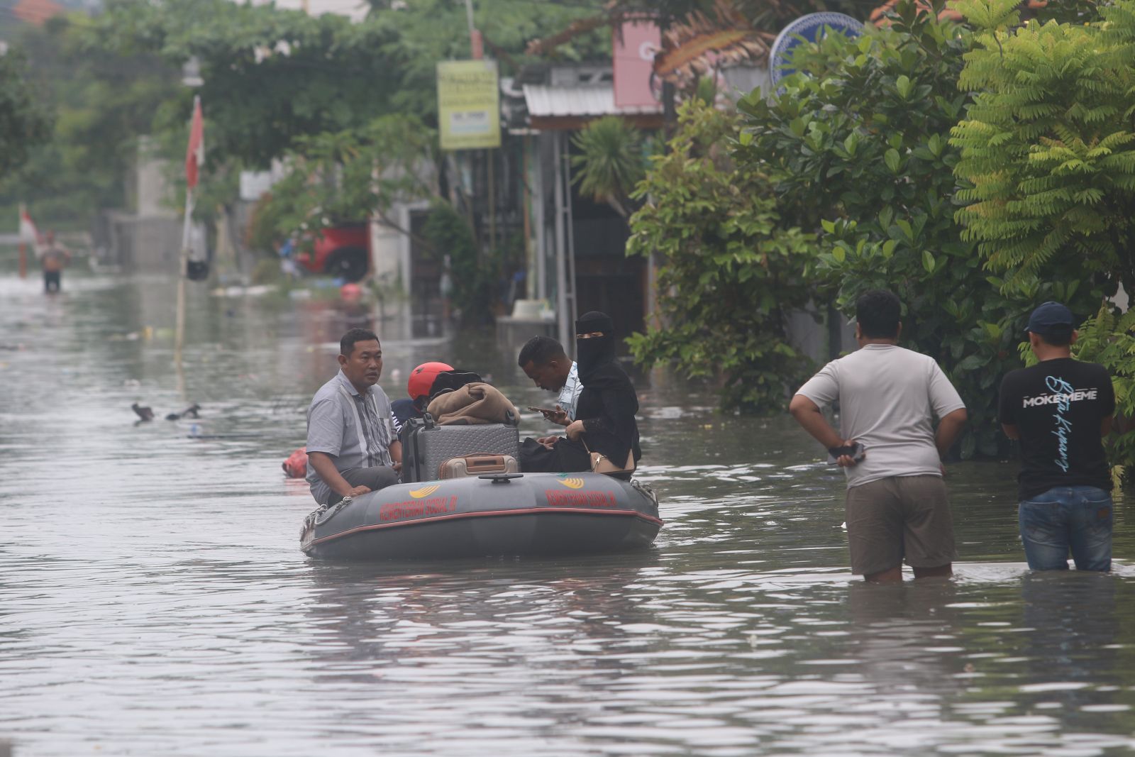 BANJIR: Wisatawan asing saat dievakuasi dg perahu karet Tagana (Taruna Siaga Bencana)Badung di kawasan Legian, Badung Minggu (14/12/2025).