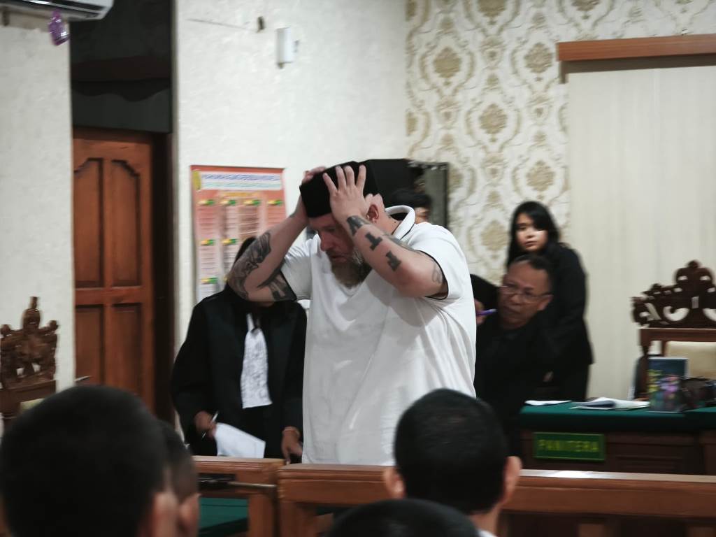 SEMRINGAH: Daniel Domalski memakai peci usai sidang putusan di PN Denpasar, Selasa (16/12).