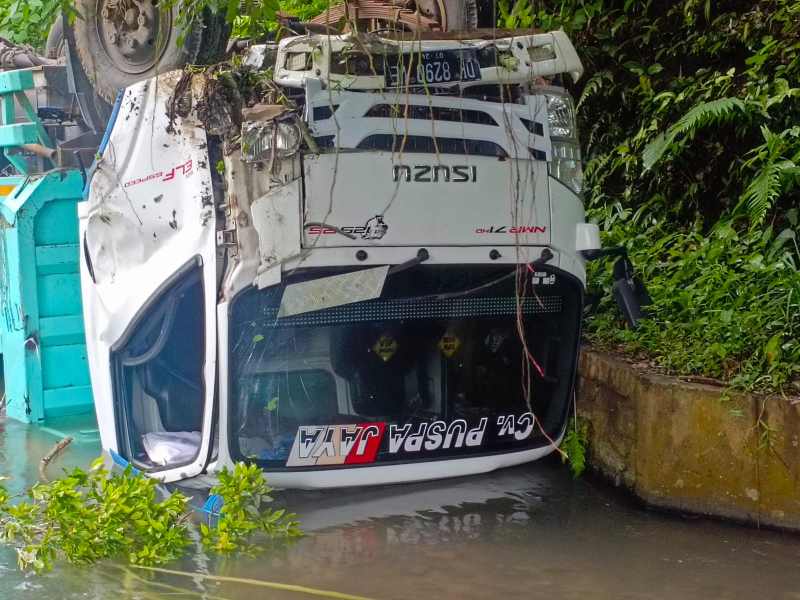 TERPEROSOK : Kendaraan roda enam yang masuk parit di dekat SDN 1 Gitgit di Jalan Raya Singaraja-Denpasar. (Foto: Polres Buleleng untuk Radar Bali)