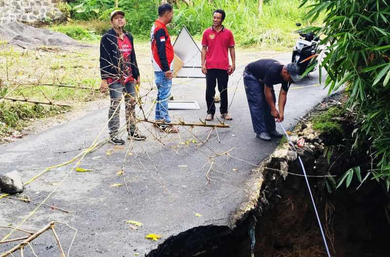 CEK KERUSAKAN : Tim Dinas PUPRPKP Tabanan yang mengecek kondisi Jalan Luwus-Petang yang jebol di Banjar Dinas Poyan, Desa Luwus Baturiti, Tabanan.(Juliadi/Radar Bali)