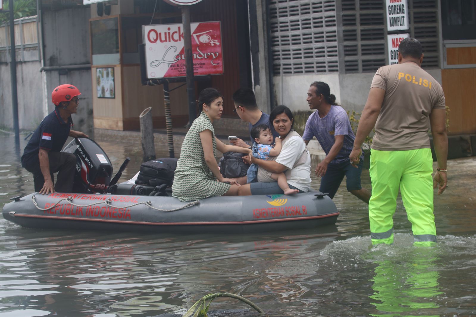 NGUNGSI: Wisatawan asing saat dievakuasi dengan perahu karet Tagana (Taruna Siaga Bencana) Badung di kawasan Legian, Badung saat banjir pada 14 Desember 2025.