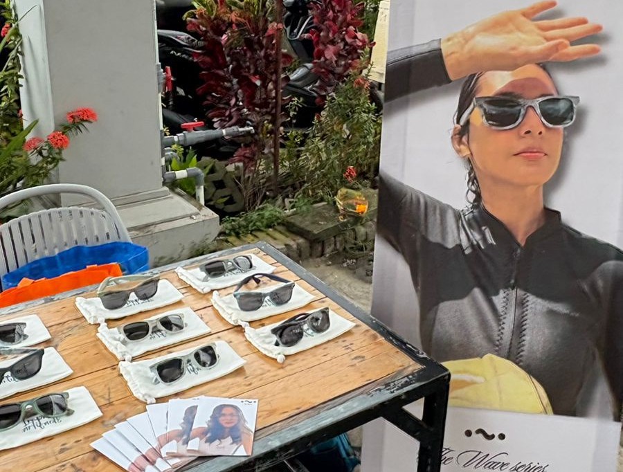 Seorang model memperagakan kacamata keren hasil daur ulang sampah plastik.