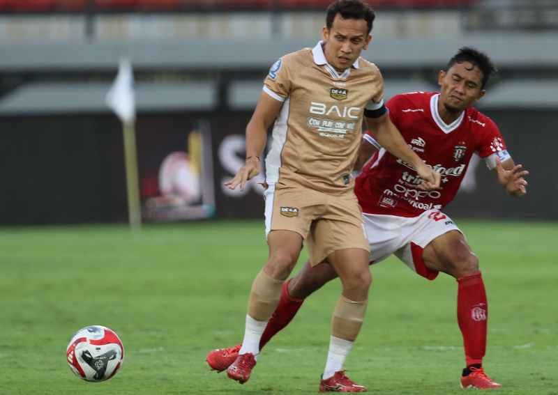KAWAL KETAT : Ricky fajrin kapten Bali United (kanan) menahan pergerakan Eggy Maulana Fikri. (miftahuddin/radar bali)