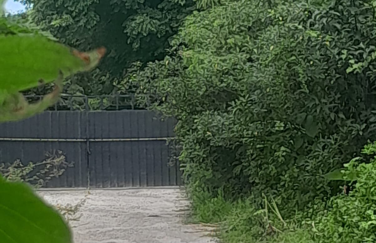 SEMBUNYI: Garis polisi di pintu masuk tempat penampungan ilegal solar itu di kawasan Jalan Pemelisan Bypass Suwung, Denpasar Selatan.