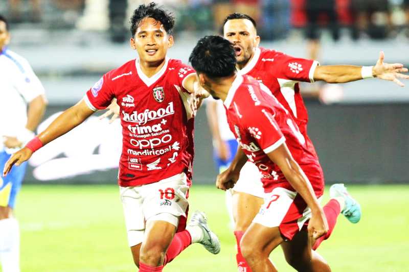 RAYAKAN KEMENANGAN : Kadek Agung (kiri) berselebrasi seusai membobol gawang Arema FC. (miftahuddin/radar bali)