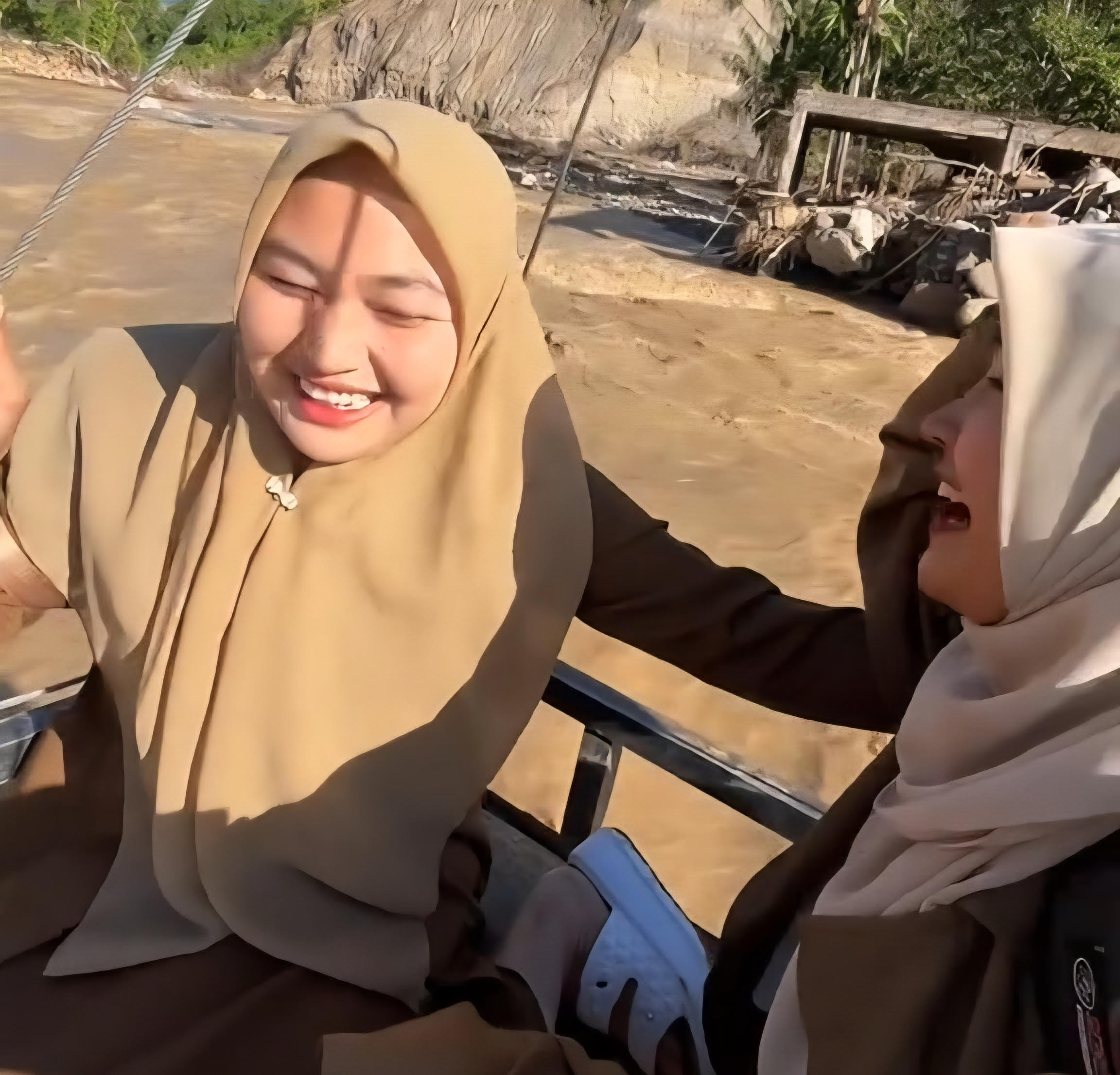 PENUH PERJUANGAN : Dua orang guru di Kecamatan Ketol sedang menyeberangi Sungai dengan tali sling untuk mengajar di sekolah. (foto:istimewa)