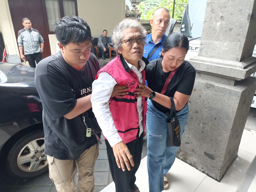 JADI PESAKITAN: I Putu Sumadi dipapah kerabatnya saat tiba di Pengadilan Tipikor Denpasar, Kamis (8/1/2026).