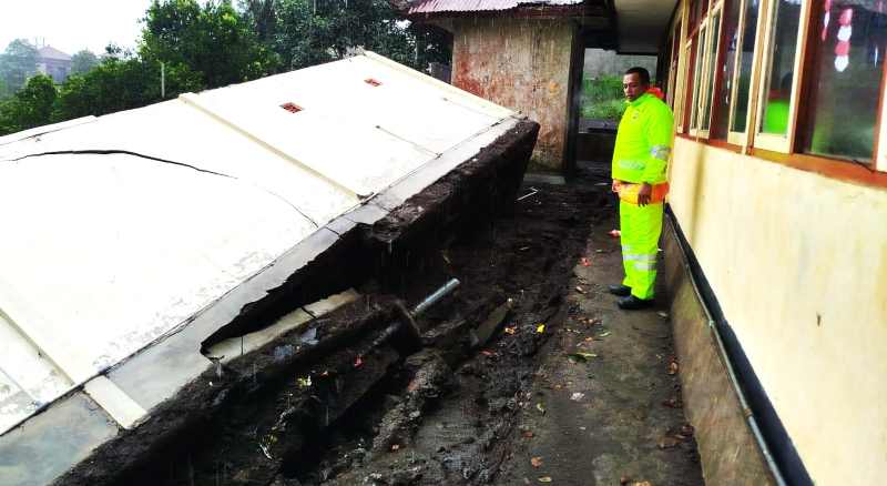 AMBROL SAAT HUJAN LEBAT: Bangunan toilet tergerus air dan ambrol ke lahan warga.(foto dok. Polres Bangli)