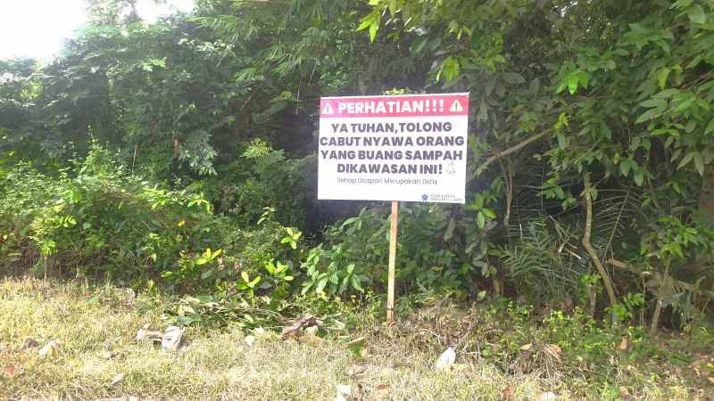 DIDOAKAN MATI KARENA SAKING KESALNYA: Salah satu Jalan Banjar Air Anakan, Desa Banyubiru, Jembrana, memasang tulisan peringatan didoakan mati bagi para pembuang sampah. (M.Basir)