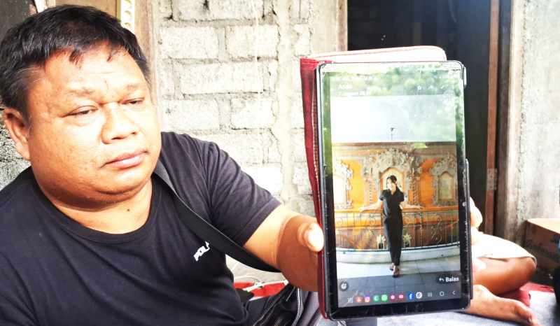 KENANGAN YANG TERSISA : Salah seorang keluarga memperlihatkan foto mendiang Ni Komang Dewantari, PMI yang meninggal tenggelam di Turki. (Zulfika Rahman/Radar Bali)
