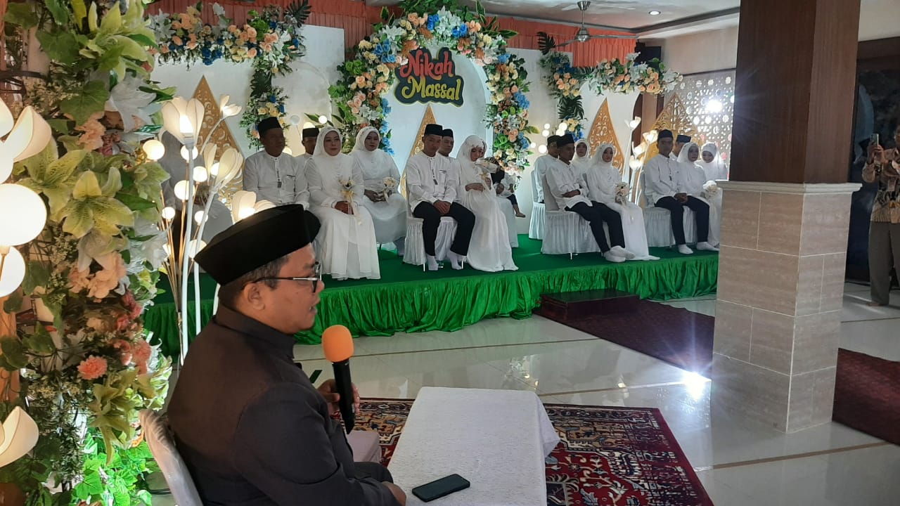 BORONG AKAD NIKAH: Kepala KUA Denpasar Barat, H. Kusnadi Abdillah saat menyampaikan nasihat pernikahan kepada 9 pasang mempelai usai akad nikah di Mushala Syuhada Padang Indah Denpasar (17/1/2026).