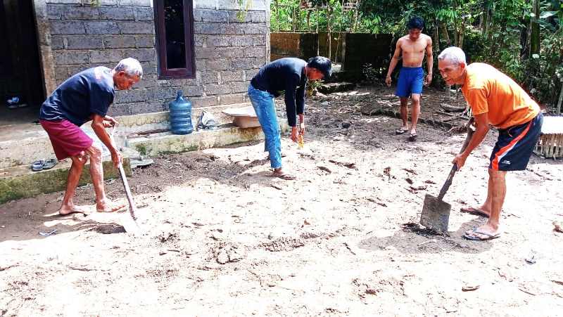 BERGOTONG ROYONG : Warga gotong royong membersihkan material banjir. (ist)