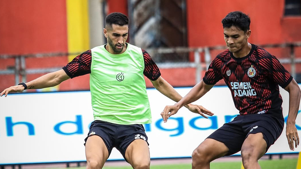 Angelo Meneses (kiri) mencetak gol perdana Semen Padang ke gawang Mike Hauptmeijer setelah perawan dalam enam laga.