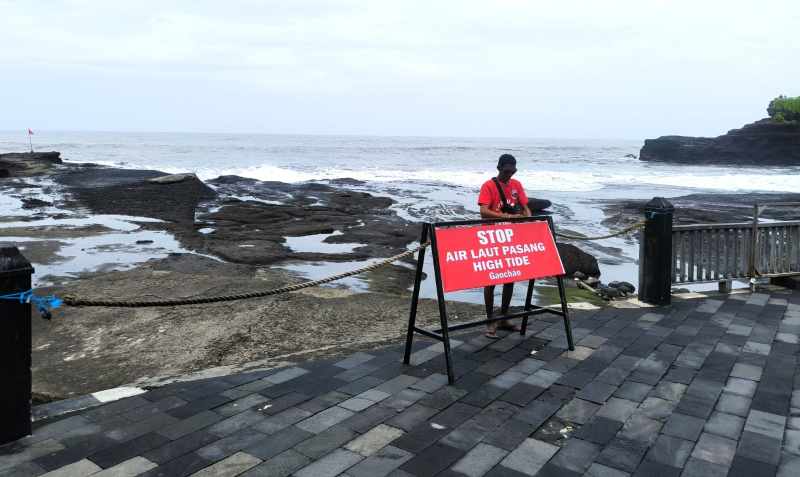 MENCEGAH MUSIBAH : Petugas Balawista yang berjaga agar tidak wisatawan menuju area pantai tanah lot saat air laut pasang. (foto juliadi/radar bali)