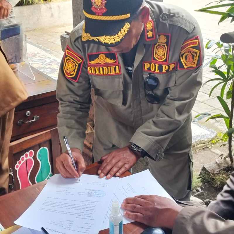 SURAT TEGURAN: Satpol PP memberikan teguran kepada satpam yang dinilai lalai melakukan pengawasan KTR di Puskesmas. (foto:Satpol PP Jembrana)