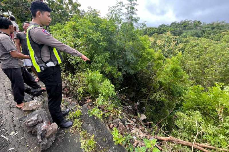 MASUK JURANG : Polisi menunjuk ke arah truk DK 8745 MF  yang terjun ke jurang sedalam 15 meter di Jalan Raya Jurang Pahit,Nusa Penida.(Polsek Nusa Penida)