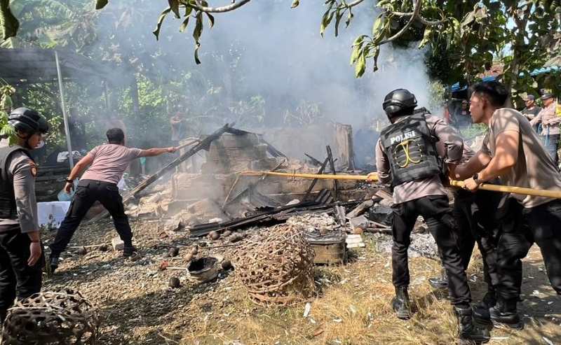 API CEPAT MEMBESAR : Aksi petugas pemadaman kebakaran rumah semi permanen milik Komang Adiartawan di Dusun Kelod II, Desa Jungutbatu, Kecamatan Nusa Penida kebakaran, (foto:Polsek Nusa Penida)