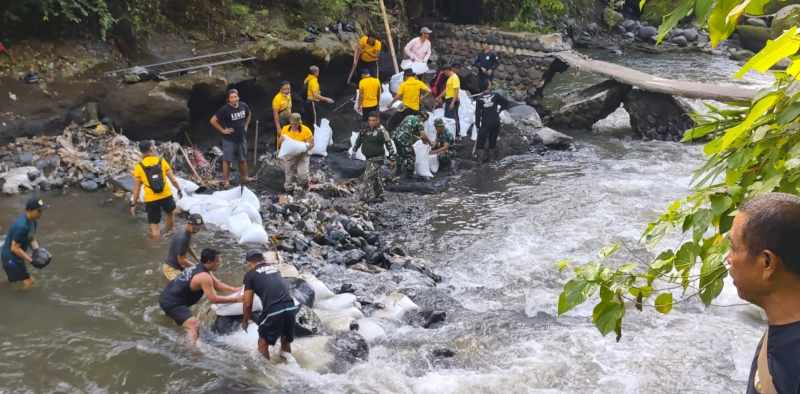 LANGSUNG GELAR GOTONG ROYONG: Tanggul bendungan yang jebol ditambal dengan bahan sederhana. (foto:Polres Gianyar)