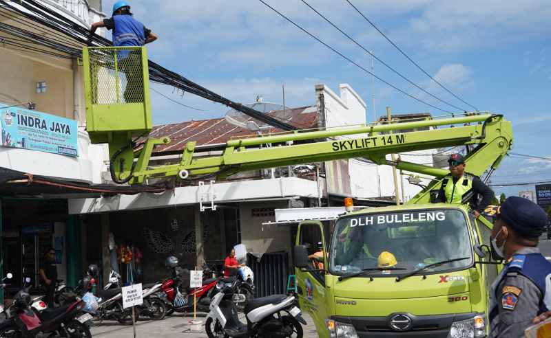BISA RAPI KALAU MAU : Penataan kabel fiber optik atau internet yang dilakukan di Jalan Pramuka. (Foto: Pemkab Buleleng untuk Radar Bali )