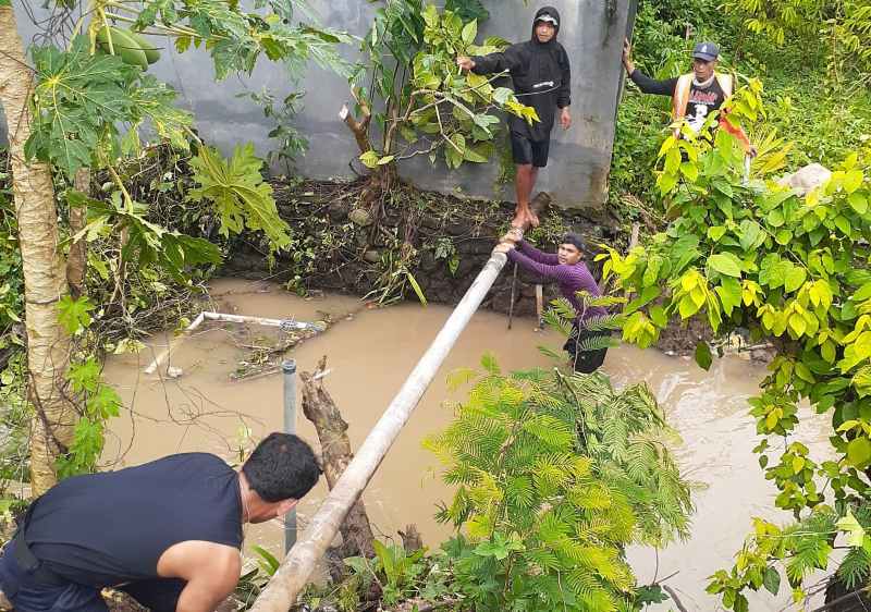 PERBAIKI PIPA SALURAN : Petugas PDAM Tirta Amertha Buana Tabanan saat melakukan perbaikan jaringan pipa distribusi air minum. (juliadi)