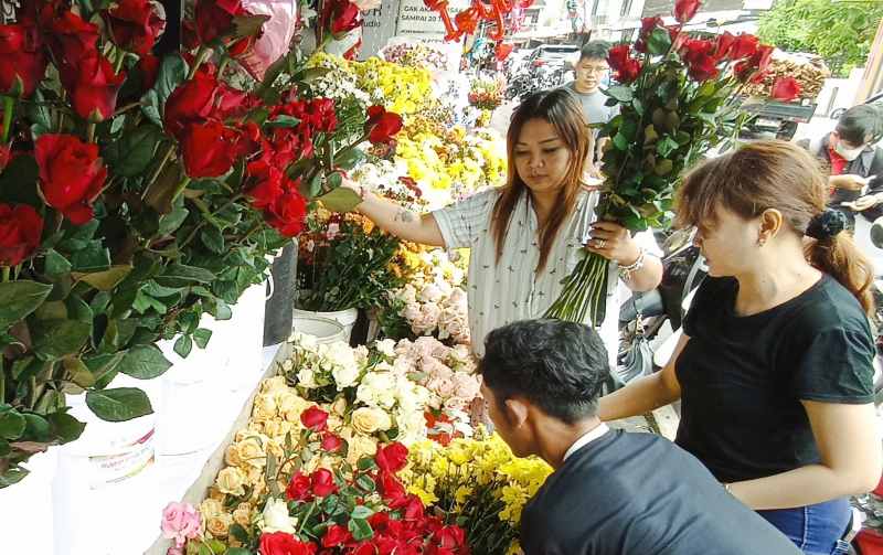 REZEKI KHUSUS SETAHUN SEKALI : Pembeli bunga di Hari Valentine, kawasan Jalan Sutoyo, Denpasar. (adrian suwanto/radar bali)