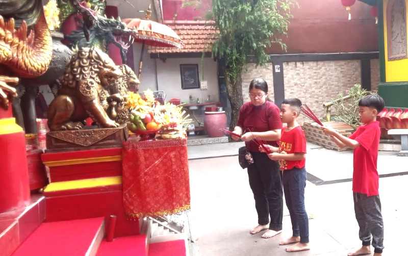 KHUSYUK BERDOA : Tampak dua bocah kyusuk berdoa dalam suasana khidmat di Kelenteng Kong Co Bio, Tabanan. (juliadi/radar bali)