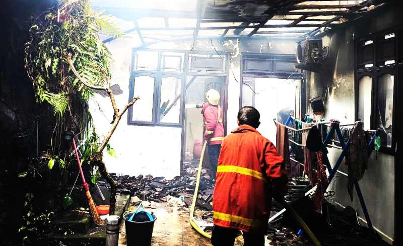 PADAMKAN API : Petugas Damkar memadamkan kebakaran di rumah I Nyoman Raditya Surya Buana di Desa Pohsanten, Kecamatan Mendoyo. (Damkar Jembrana)