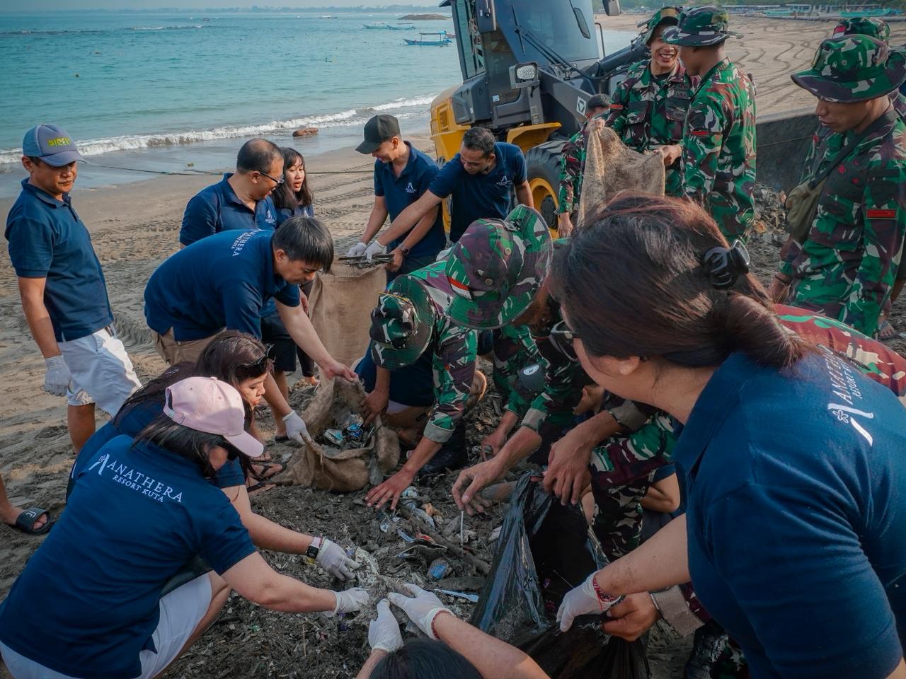 BIRU HIJAU: Para karyawan Anathera Resort Kuta  bersama TNI berbauh memberishkan pantai Jerman, Kuta Badung.