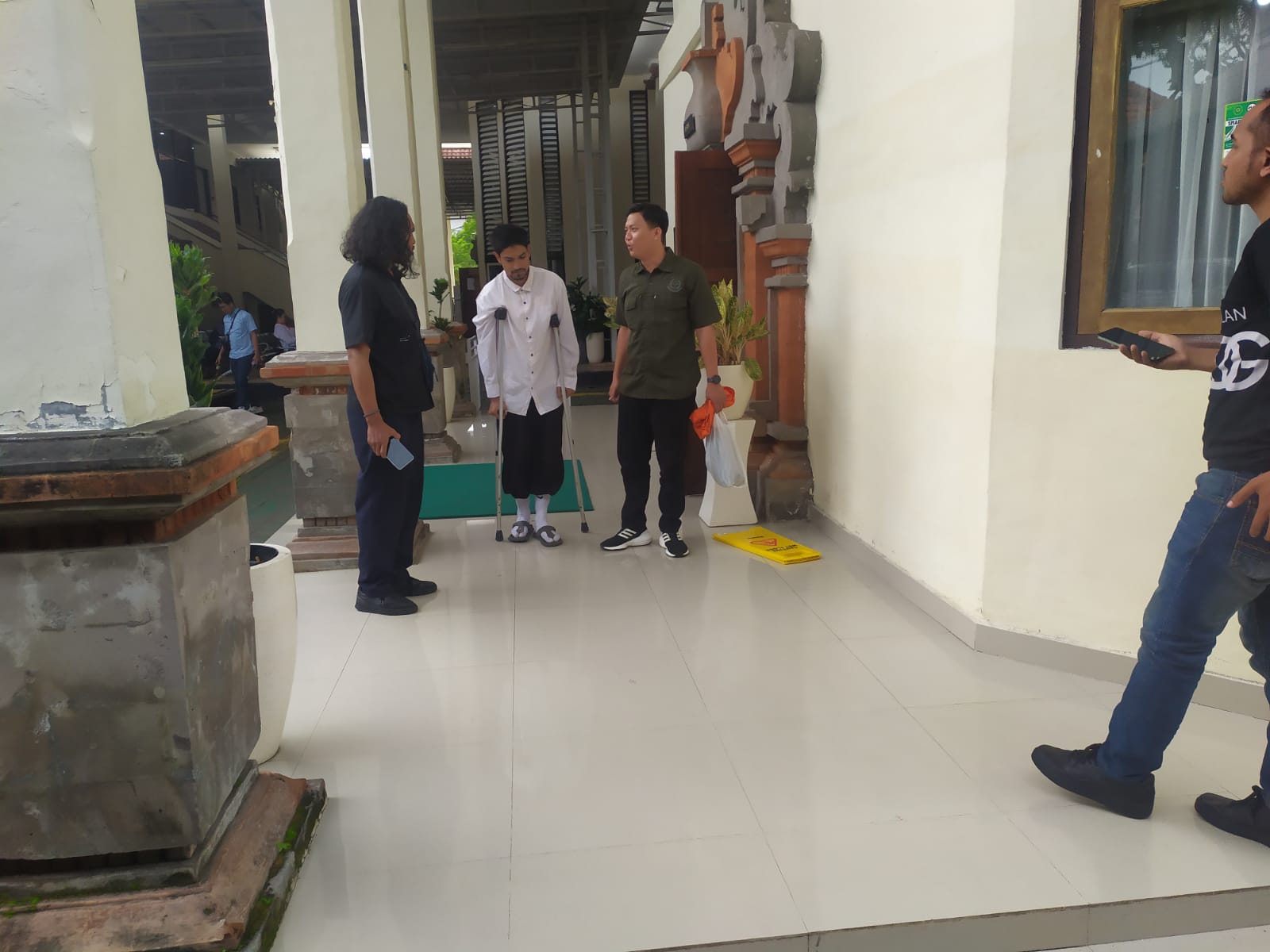 PAKAI KRUK: Warga negara Belanda Rashim Abdoelrazak memakai kruk setelah sidang di PN Denpasar, Selasa (24/2/2026).