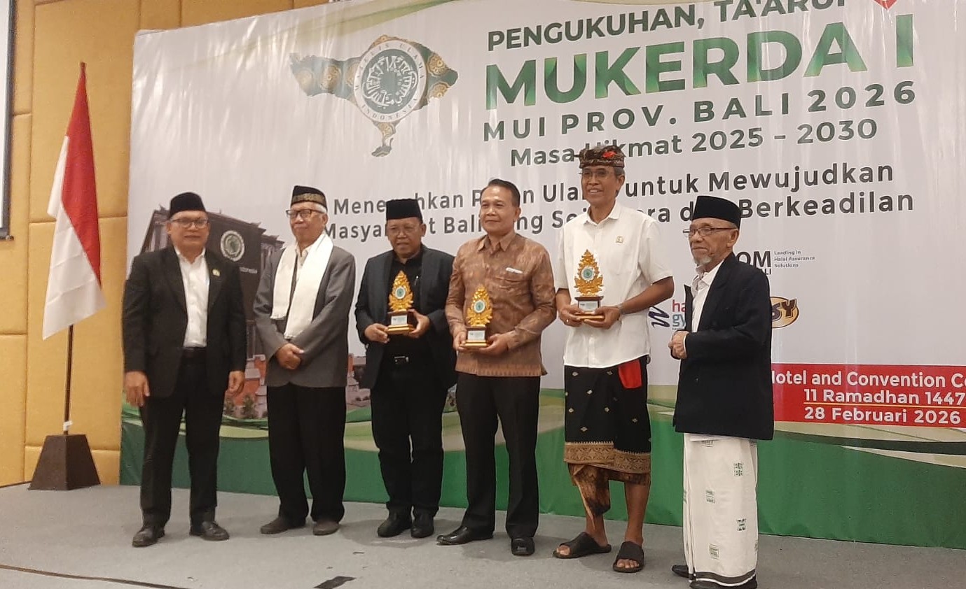 PENGHARGAAN: Cenderamata kepada para tokoh yang diserahkan Ketua MUI Bali KH Mahrusun Hadiyono didampingi Sekretaris H. Ismoyo Soemarlan, disela Pengukuhan dan Mukerda I MUI Bali, 28 Februari 2026.