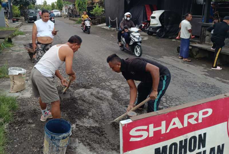 BERGOTONG ROYONG : Warga Banjar Dinas Kebon, Desa Nyitdah Kecamatan Kediri Tabanan yang melakukan perbaikan jalan secara swadaya.(juliadi)