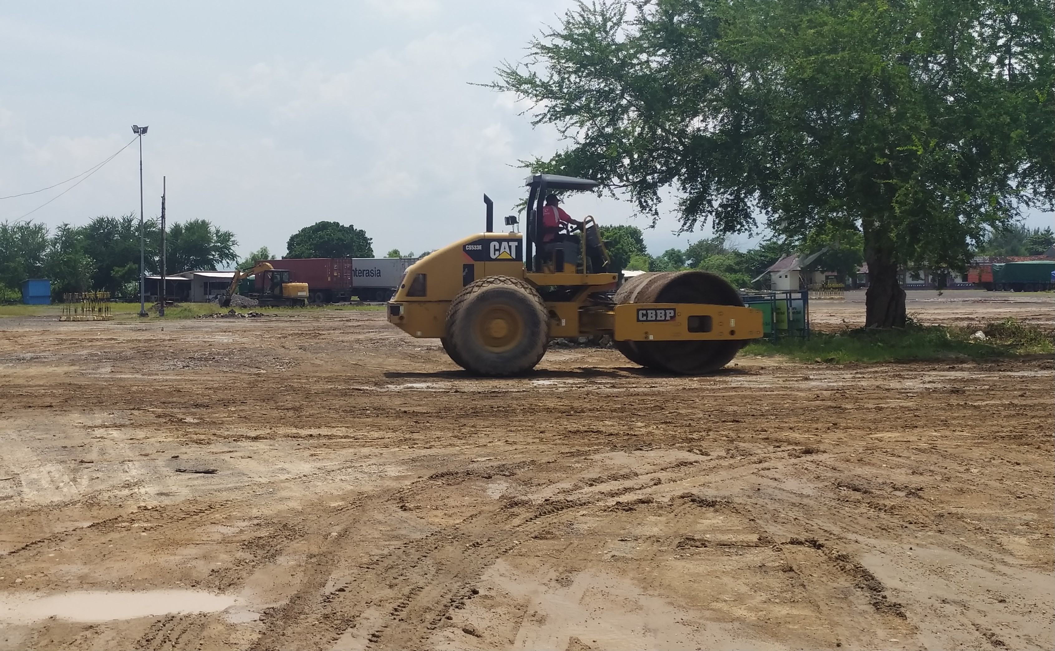 KEJAR TENGGAT: Dua alat berat melakukan perbaikan Landasan Parkir Kargo Gilimanuk. ( M. Basir/Radar Bali)