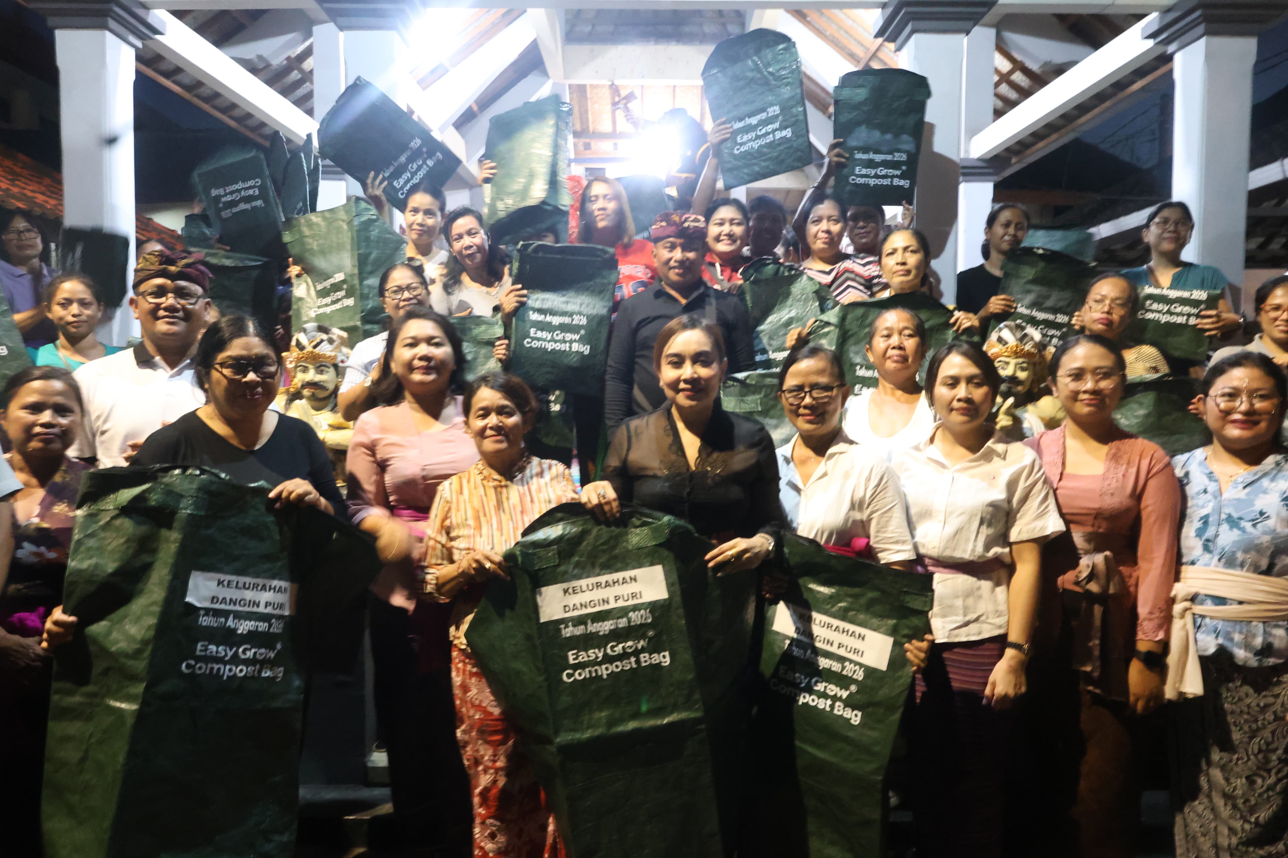 Sekretaris I TP PKK Kota Denpasar, Ny. Ayu Kristi Arya Wibawa, saat menyerahkan Compost Bag di Banjar Kayumas Kelod, Kelurahan Dangin Puri, Minggu (8/3).  
