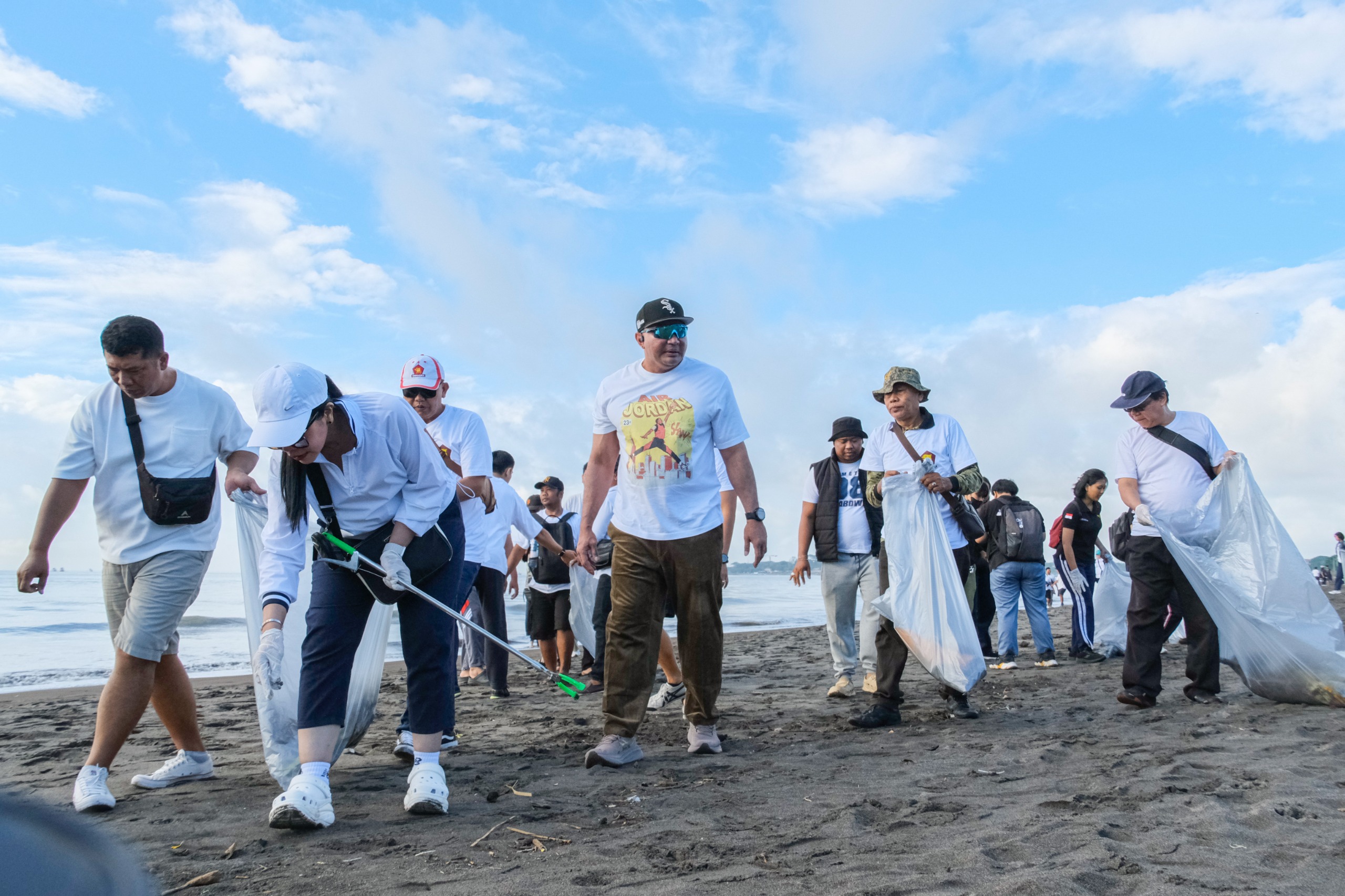 KERJA BAKTI: Gerindra Denpasar bersama anak-anak muda Kota Denpasar membersihkan Pantai Padang Galak, Sabtu (14/3/2026). (DPD Gerindra Bali for Radar Bali)  