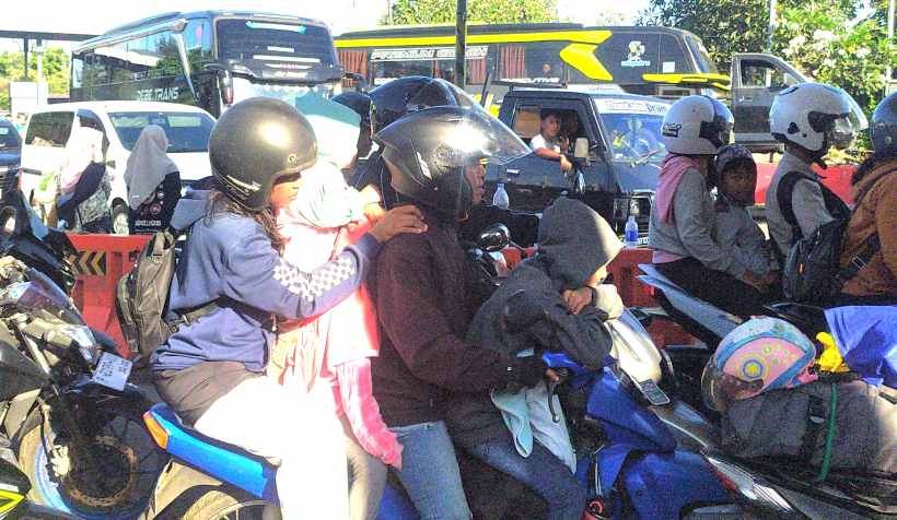 PERJUANGAN BERAT DEMI KELUARGA: Para pemotor yang terjebak antrean berapa diantaranya membawa anggota keluarga termasuk balita. (foto-foto: M.Basir/Radar Bali)