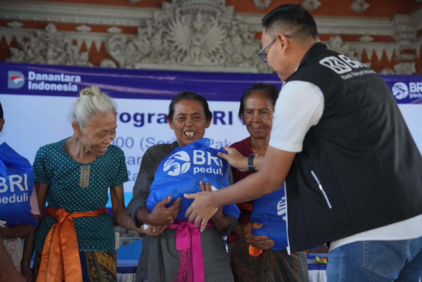Regional CEO BRI Region 17 Denpasar, Hery Noercahya menyerahkan bantuan paket sembako kepada masyarakat Desa Sarimekar, Buleleng (12/3/2026).