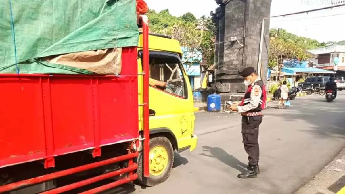 PERKETAT PEMERIKSAAN : Polisi melakukan pemeriksaan kendaraan di Padangbai. (zulfika Rahman)