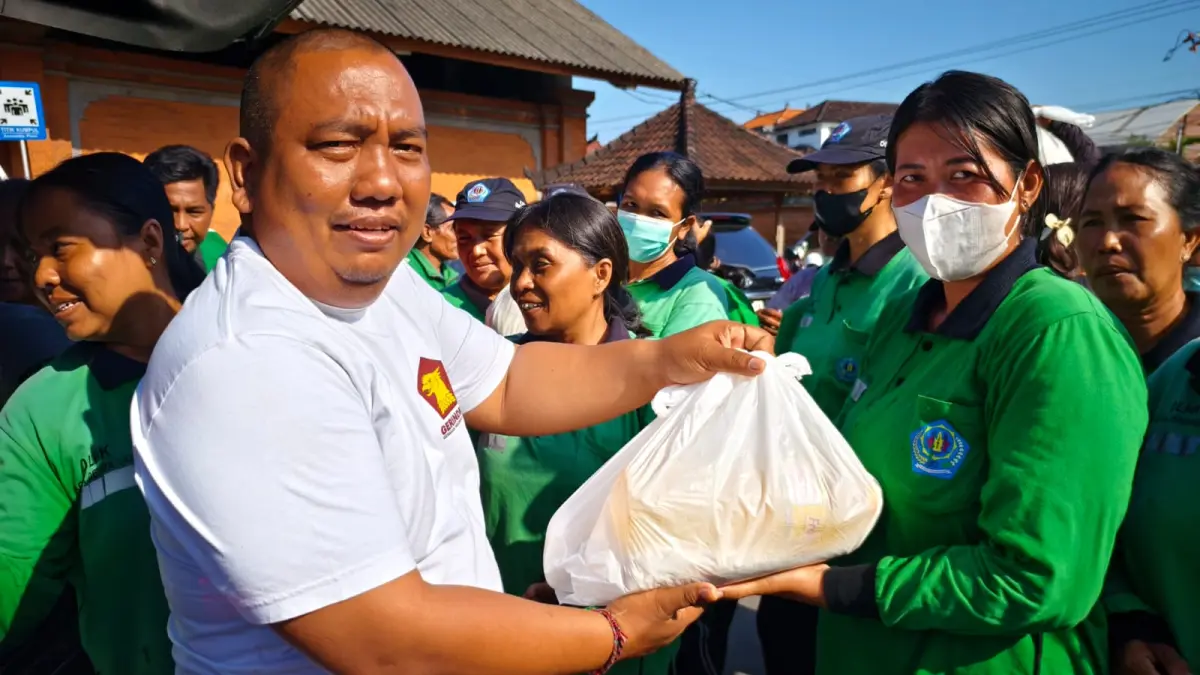 PEDULI: Ketut Ngurah Aryawan memberikan puluhan paket sembako dibagikan kepada para tukang sapu di Lapangan Kompyang Sujana, Sabtu (28/3/2026). (Ketut Ngurah Aryawan for Radar Bali)