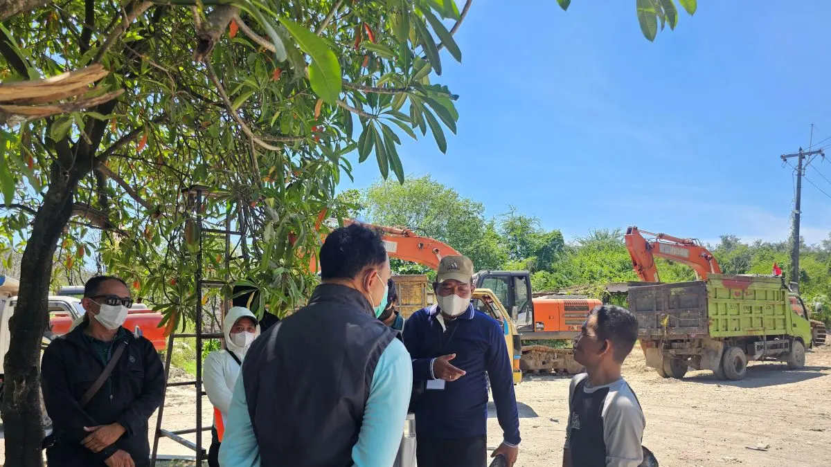 BINGUNG: Sopir truk dari jasa sampah mandiri sedang bernegosiasi karena truk sampah yang tidak lolos, tampak berbincang dengan petugas meakai rompi hitam atas kaus lengan panjang berwarna biru muda dan membawa HT di jalur masuk TPA Suwung Rabu 1 April 2026. (NI KADEK NOVI FEBRIANI/radarbali.id)
