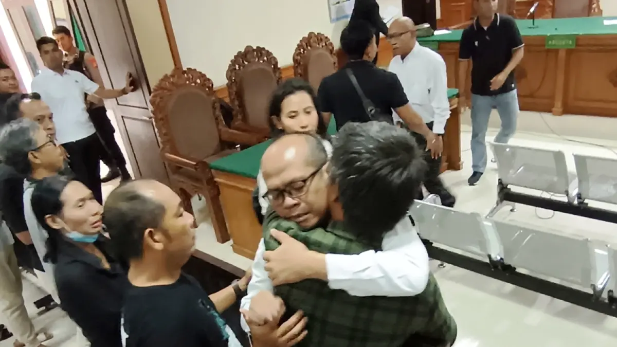 PLOT TWIST: Terdakwa I Wayan Nonok Aryasa (dua dari kanan, memakai kacamata) memeluk kerabatnya di Pengadilan Tipikor Denpasar, Kamis (2/4/2026). Foto: M. Sandijaya/Radarbali.id