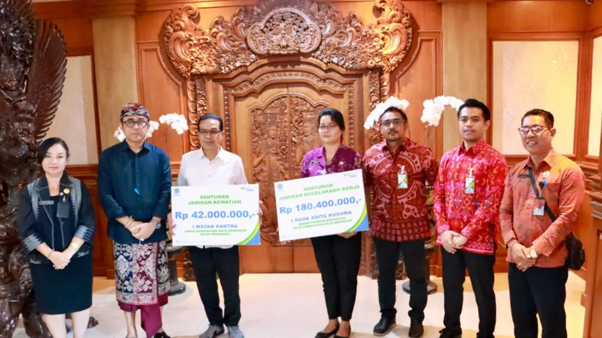 Wali Kota Denpasar I Gusti Ngurah Jaya Negara (dua dari kiri), menyalurkan secara simbolis santunan Jaminan Kecelakaan Kerja (JKK) di Lobi kantor Wali Kota Denpasar, Selasa (7/4).
