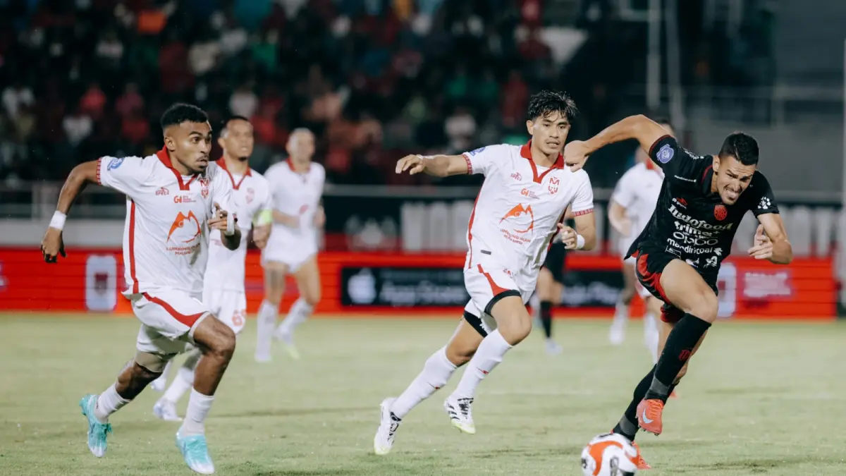 Striker Bali United Boris Kopitovic berduel dengan bek kiri Malut United Yance Sayuri dalam laga putaran pertama BRI Super League 2025 2026. 
