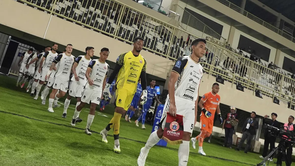 Kapten Persija Rizky Ridho memimpin timnya memasuki lapangan saat bertanding melawan Persib Bandung. 