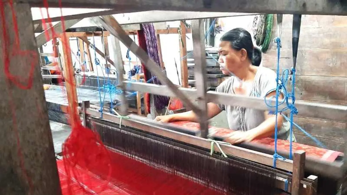 TUNTASKAN PEMBUATAN KAIN: Perajin sedang menuntaskan pembuatan kain tenun di Desa Gelgel. (foto: Dewa Ayu Fitri Arisanti)