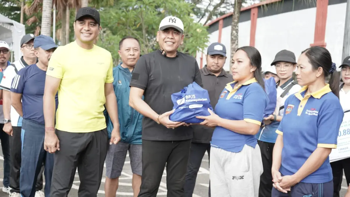 Bupati Karangasem I Gusti Putu Parwata (tengah) bersama Kapolres Karangasem AKBP I Made Santika, menyerahkan bantuan sembako kepada petugas kebersihan serangkaian May Day yang di pusatkan di Jalan Veteran Amlapura, Minggu (3/5).