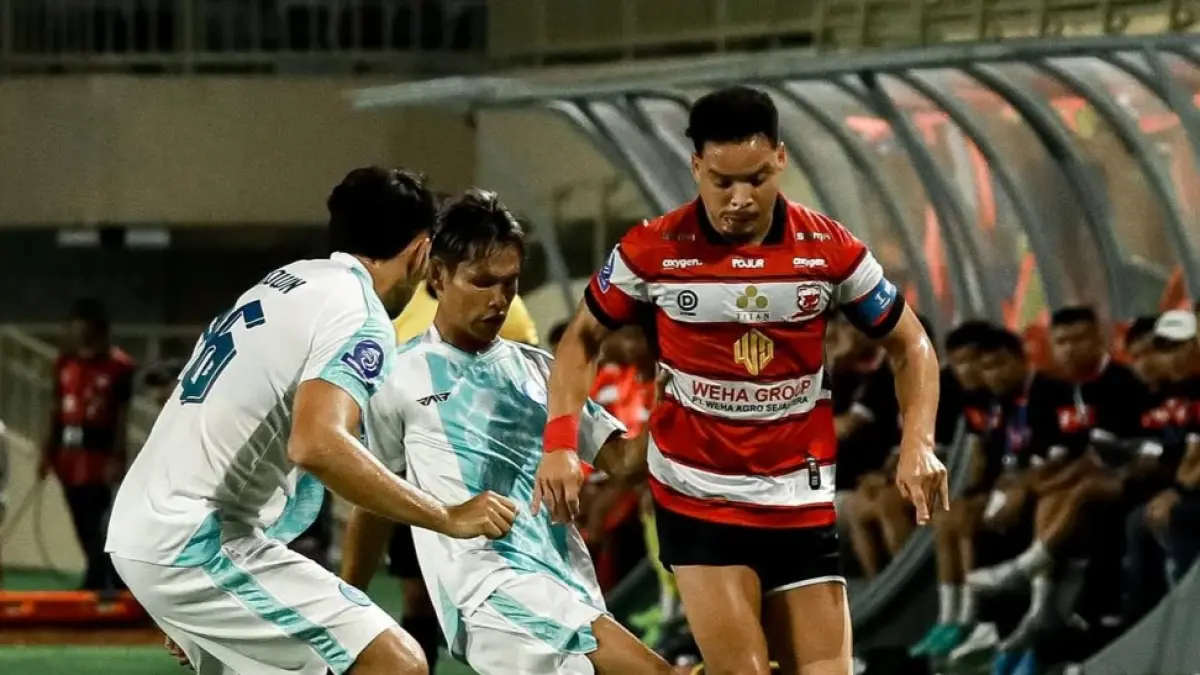 Kapten Madura United Lulinha mencoba melepaskan diri dari kawalan pemain PSBS Biak dalam pertemuan kedua tim di BRI Super League. 