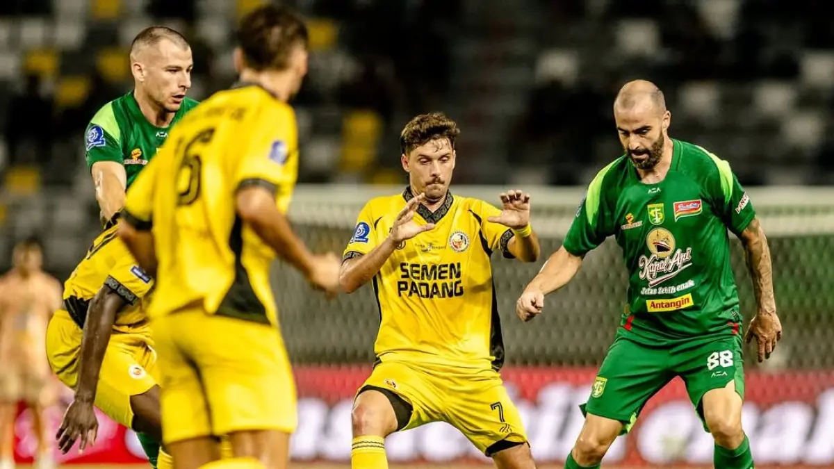 Gelandang Persebaya Milos Raickovic berupaya menembus pertahanan Semen Padang dalam laga pekan keenam BRI Super League. 