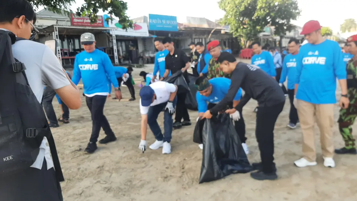 SAMPAI BERSIH: Ketua Umum Pengurus Pusat Pemuda Muhammadiyah, Dzulfikar Ahmad Tawalla dan Wamenko Pangan Hanif Faisol Nurofiq memungut puntung rokok saat menyisir pantai Kedonganan Jimbaran, Jumat 22 Mei 2026. (M/RIDWAN/radarbali.id)