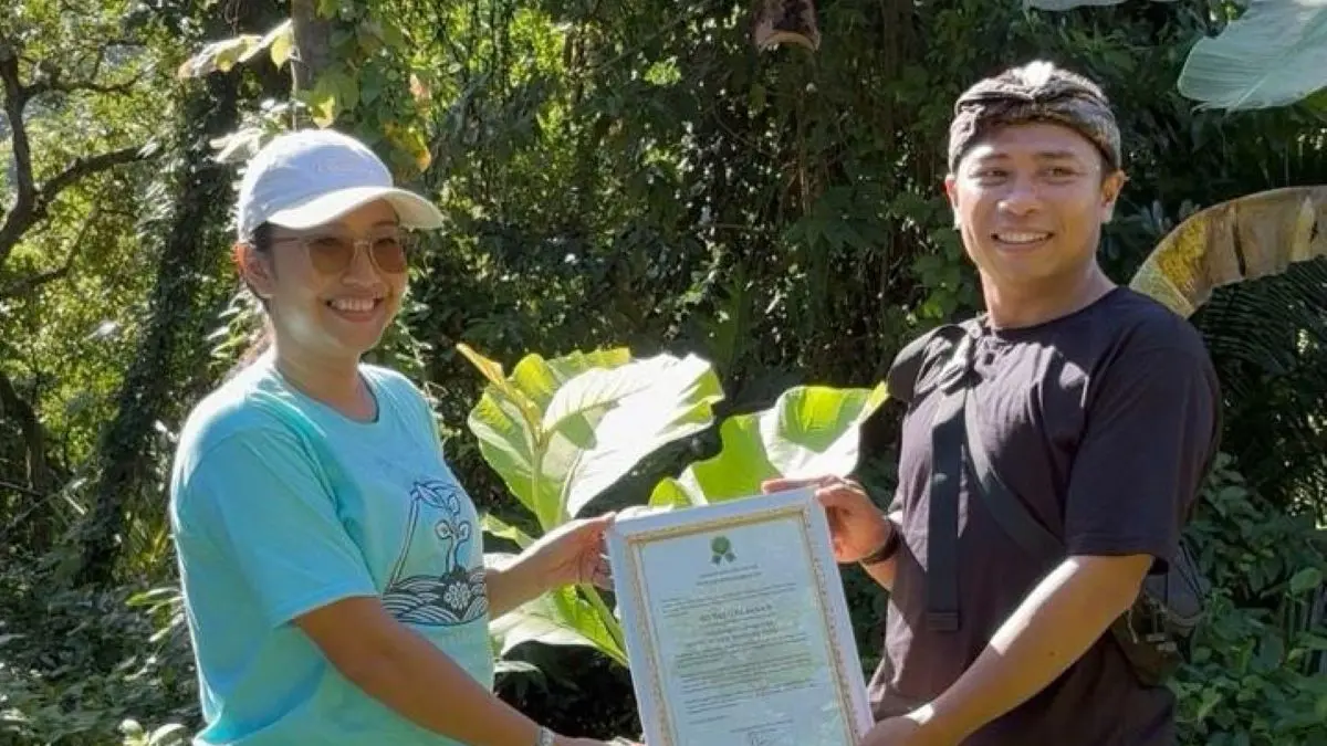 HIJAU LESTARI: Ketua Yayasan Jati Nusa Lestari, Novi Dwi Jayanti saat menyerahkan sertifikat Satu Desa Satu Hutan Jati Nusantara di Desa Adat Besan Klungkung Bali.